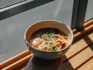 Eierflockensuppe mit Erbsen, Pilzen und Frühlingszwiebeln in einer Schale