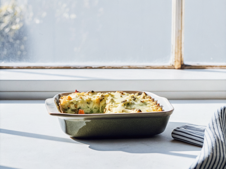 Kartoffelauflauf mit Möhren, Kohlrabi und Erbsen unter goldbraunem Käse