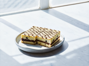 Donauwelle-Stücke mit Kirschen, Vanille-Buttercreme und gewelltem Schokoladenguss
