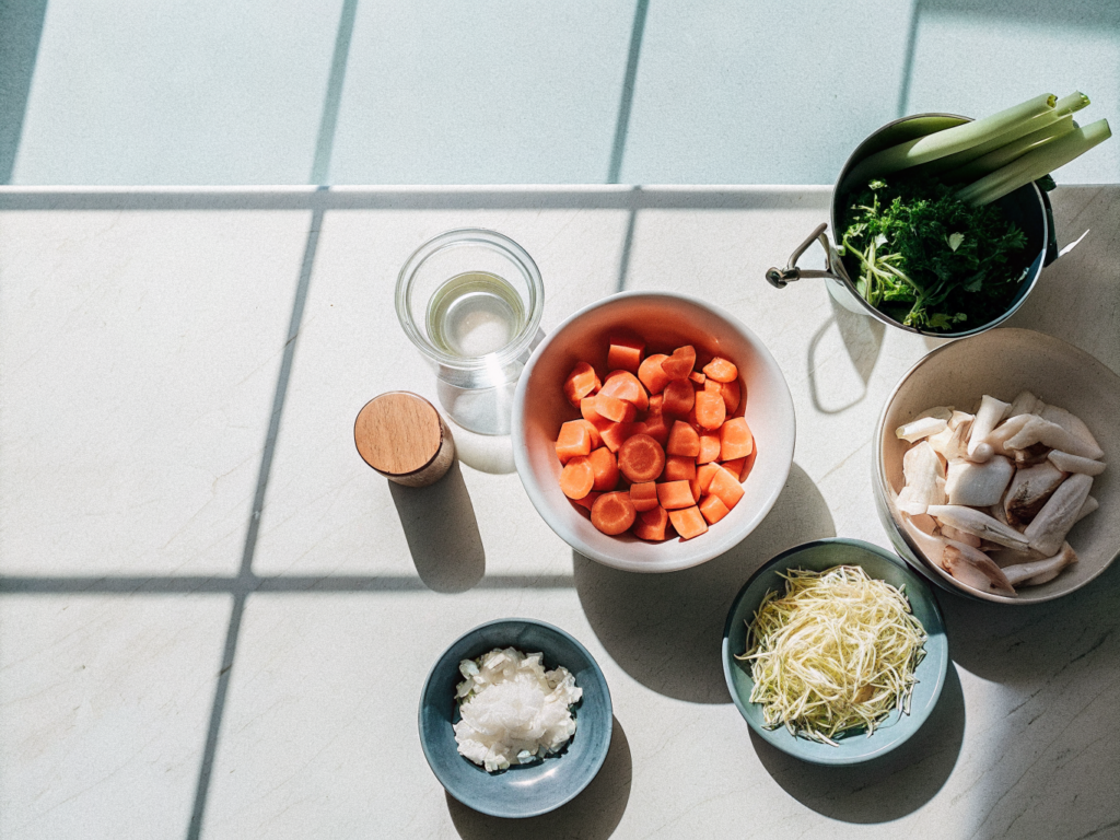 One-Pot-Spätzle mit Hähnchen und Gemüse 2 Zutaten für One-Pot-Spätzle mit Hähnchen und Gemüse auf einer Küchenarbeitsfläche.