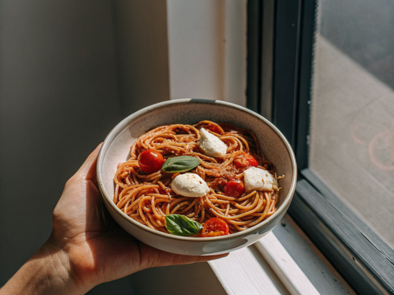 Vollkornspaghetti mit Kirschtomaten, Mozzarella und frischem Basilikum in einer Schale