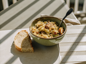 Polnischer Bigos mit Sauerkraut, Kohl, Schweinefleisch und Räucherwurst in einer Keramikschale