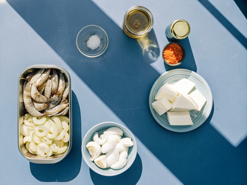 Französischer Fischeintopf mit schneller Rouille 2 Zutaten für Fischeintopf mit Garnelen, Muscheln, Weißfisch, Fenchel und Tomaten auf einer Arbeitsfläche