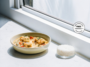 Cremiger Garnelen-Eintopf mit Kokosmilch, Tomaten und Koriander, dazu Reis
