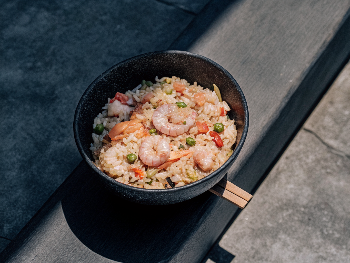 Gebratener Reis mit Garnelen aus dem Wok 1 Gebratener Reis mit Gemüse und Ei, darauf Garnelen mit etwas Sauce