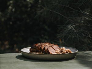 Rinderschmorbraten mit Rotweinsauce und Spätzle auf einem Keramikteller