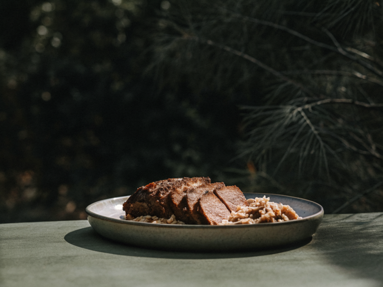 Rinderschmorbraten mit Rotweinsauce und Spätzle auf einem Keramikteller