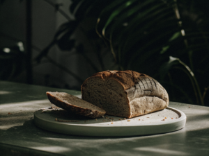 Angeschnittenes Roggenmischbrot mit dunkler Kruste auf einem schlichten Brett