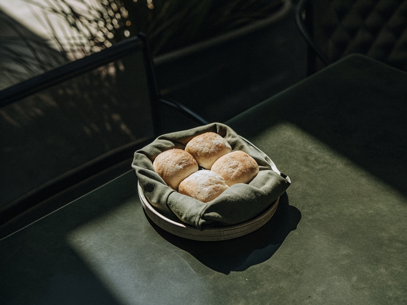 Einfache Brötchen aus Hefeteig 1 Goldbraune Brötchen in einem mit Leinen ausgelegten Korb auf dem Frühstückstisch