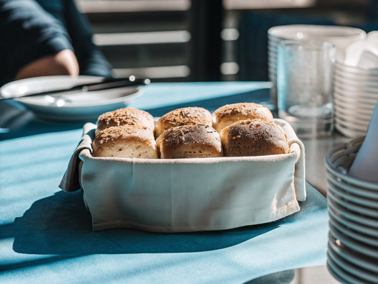 Acht goldbraune Brötchen mit knuspriger Kruste in einem mit Leinen ausgelegten Brotkorb