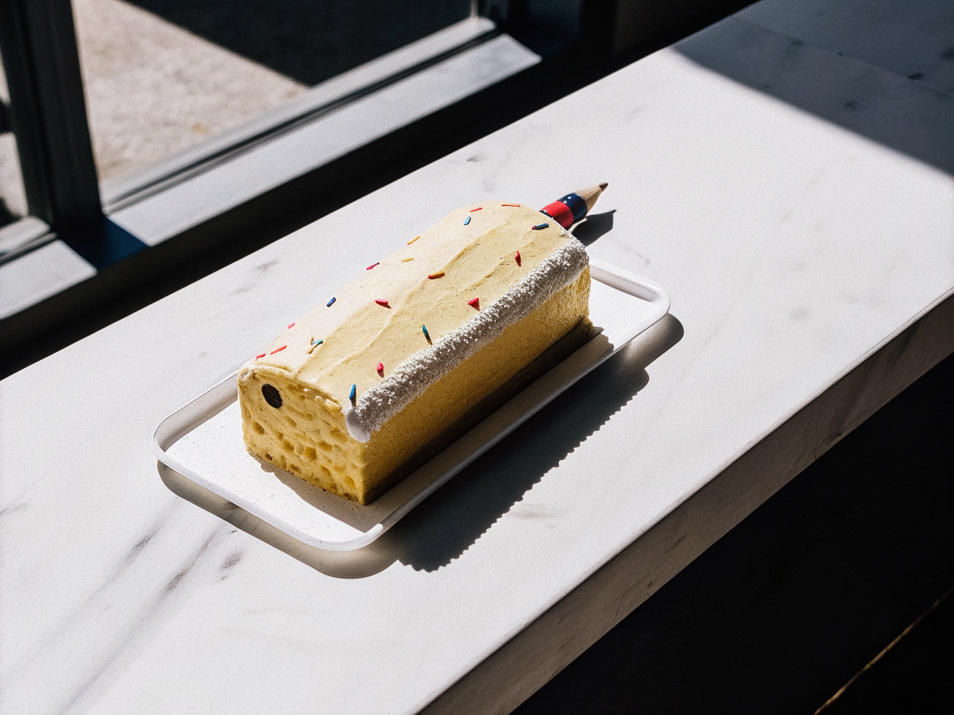 Buntstift-Torte mit Erdbeercreme zur Einschulung 1 Buntstift-Torte mit gelber Creme, bunten Fondantbuchstaben und Streuseln auf einer weißen Platte