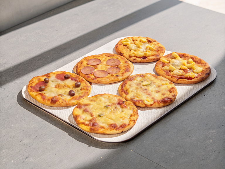 Sechs Casabe-Pizzen mit geschmolzenem Mozzarella, Chorizo, Putenaufschnitt, Mais, Oliven und Paprika